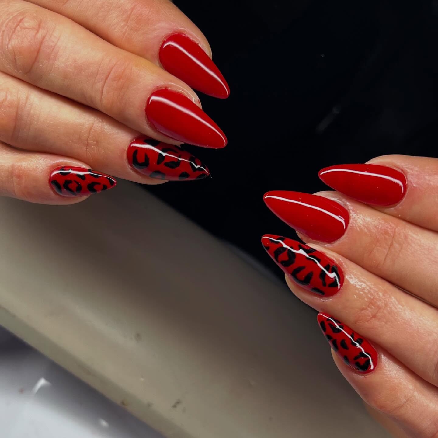 Bold stiletto red gelish nails with dark leopard animal print accents