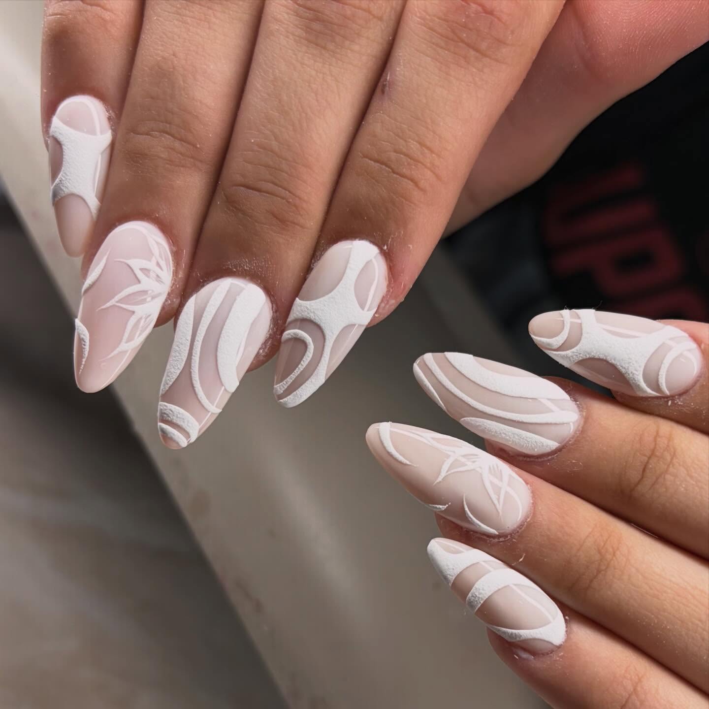 Elegant almond-shaped nude nails with white textured 3D lace and botanical embossing