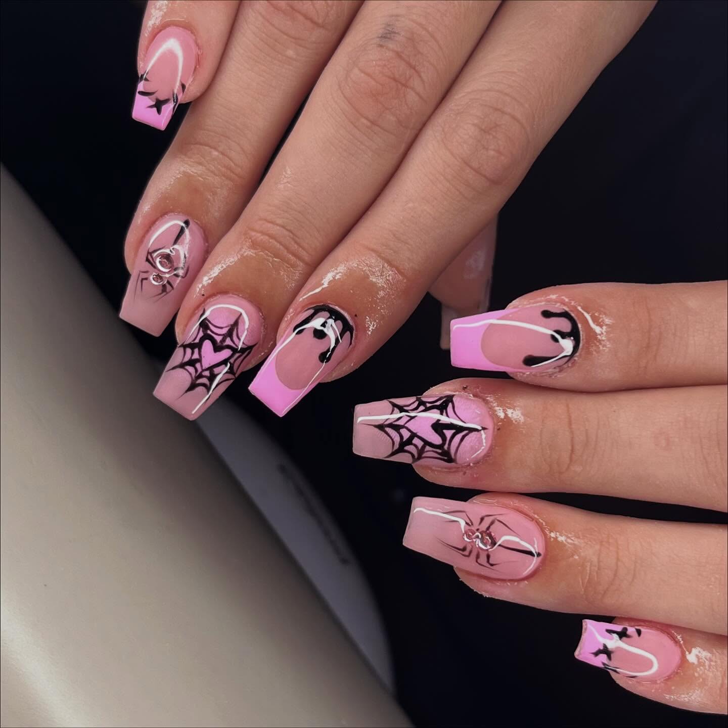 Pink square nails with spiderweb nail art, black drip french tips and heart accents